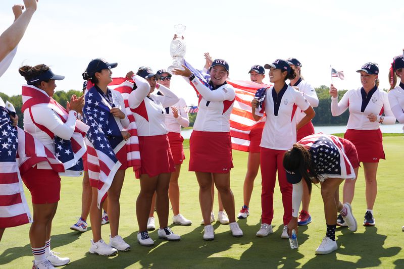 United States' Lilia Vu, center, hold the winner's trophy after the United States won the Solheim Cup golf tournament against Europe at the Robert Trent Jones Golf Club, Sunday, Sept. 15, 2024, in Gainesville, Va. (AP Photo/Matt York)