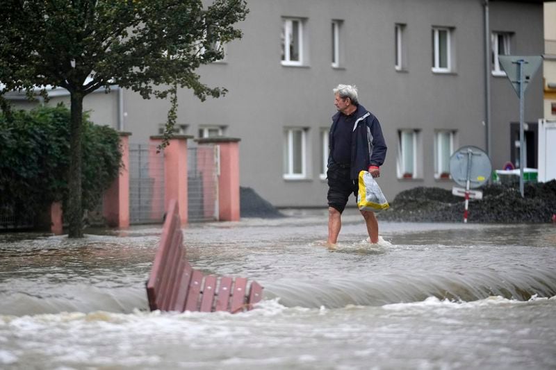 A resident walks through a flooded street in Liotvel, Czech Republic, Monday, Sept. 16, 2024. (AP Photo/Petr David Josek)