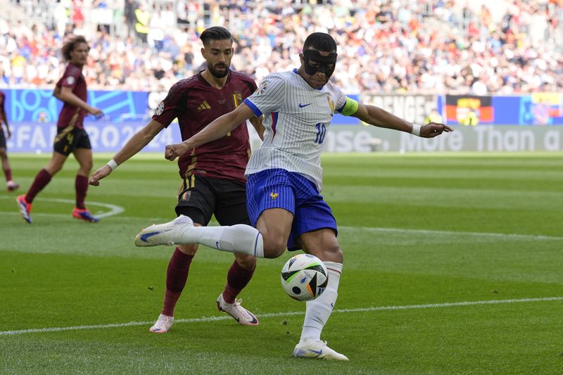 Kylian Mbappe of France, front, clears the ball past Belgium's Yannick Carrasco during a round of sixteen match between France and Belgium at the Euro 2024 soccer tournament in Duesseldorf, Germany, Monday, July 1, 2024. (AP Photo/Martin Meissner)