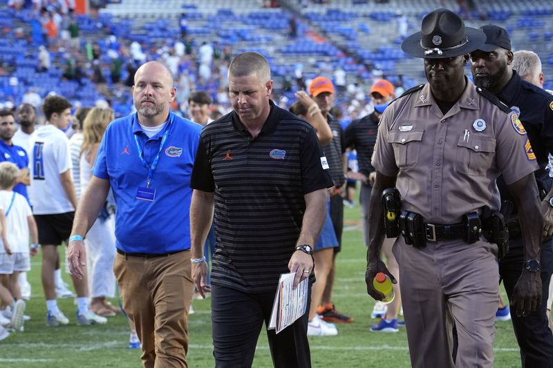 Florida head coach Billy Napier, center, walks off the field after his team was defeated by Miami, 41-17, in an NCAA college football game, Saturday, Aug. 31, 2024, in Gainesville, Fla. (AP Photo/John Raoux)