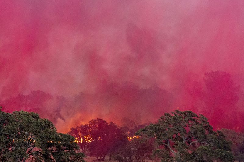 Fire retardant dropped from a plane drifts over the Aero Fire burning in the Copperopolis community of Calaveras County, Calif., on Monday, June 17, 2024. (AP Photo/Noah Berger)
