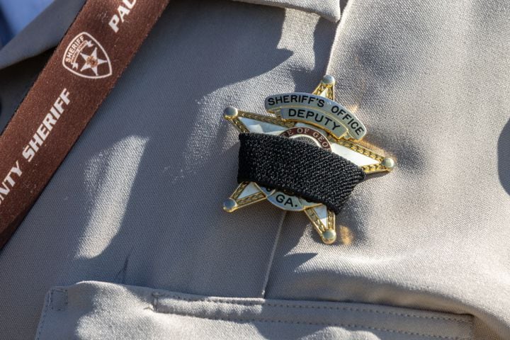 Mourning Bands are worn by Paulding County Sheriff deputies in honor of  Paulding County Deputy Brandon Cunningham was  killed in the line of duty on Sunday, Aug. 18, 2024. (John Spink/AJC)