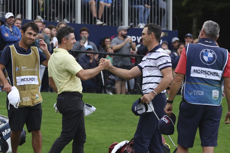 Billy Horschel of the United States, right shakes hands with Rory McIlroy, of Northern Ireland, on the 18th green with Horschel winning a playoff to win the British PGA golf Championship at Wentworth golf club in Wentworth, England, Sunday, Sept. 22, 2024. (AP Photo/Ian Walton)