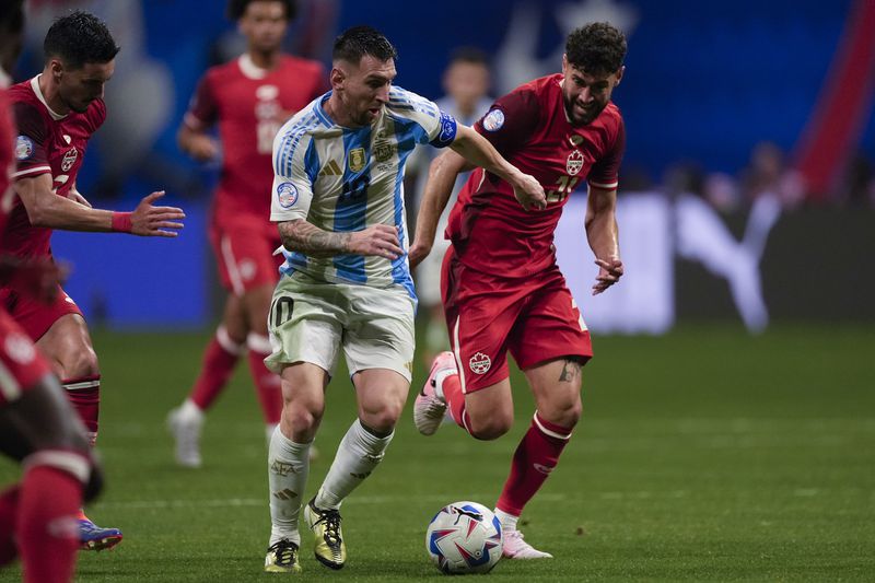 Argentina's Lionel Messi, 10, and Canada's Jonathan Osorio battle for the ball during a Copa America Group A soccer match in Atlanta, Thursday, June 20, 2024. (AP Photo/Mike Stewart)