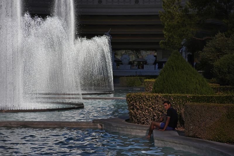 A person cools off in a fountain at Caesars Palace along the Las Vegas Strip, Sunday, July 7, 2024, in Las Vegas. The city set an all time record high of 120 F (48.8 C) Sunday as a heat wave spread across the Western U.S. sending many residents in search of a cool haven from the dangerously high temperatures. (AP Photo/John Locher)