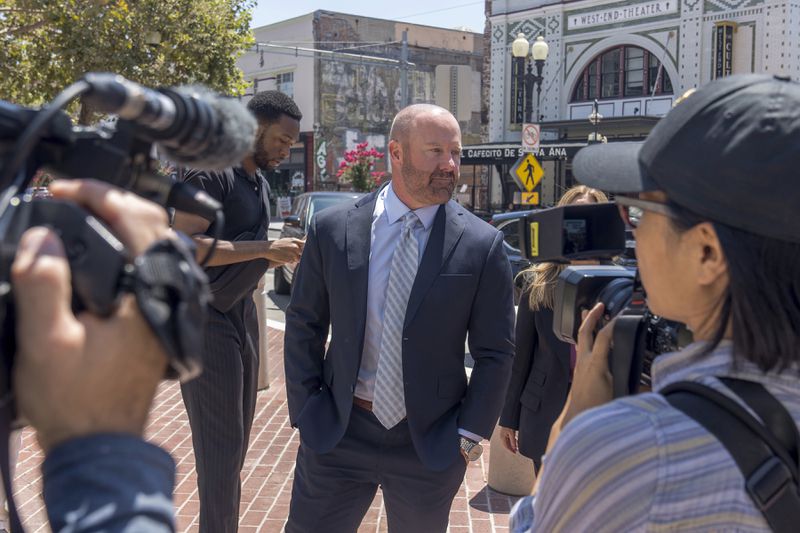 Mathew Bowyer, center, a Southern California bookbinder, arrives in federal court in Santa Ana, Calif., Friday, Aug. 9, 2024. (AP Photo/Damian Dovarganes)