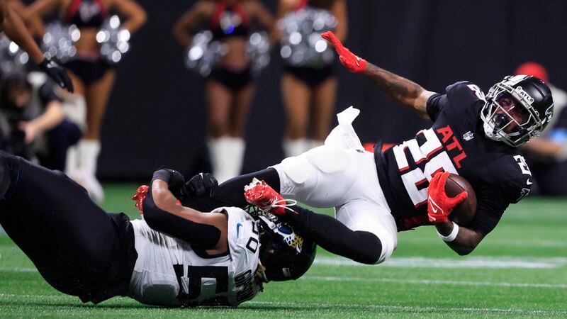 Jacksonville Jaguars defensive end Trevis Gipson (50) hits Atlanta Falcons running back Carlos Washington Jr. (28) in the first half of an NFL preseason footballl game, Friday, Aug. 23, 2024, in Atlanta. (AP Photo/Butch Dill)