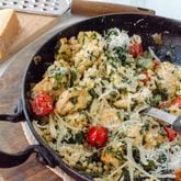 Skillet Spinach Chicken served with pearl couscous and grape tomatoes, topped with Parmesan cheese.
(Virginia Willis for The Atlanta Journal-Constitution)