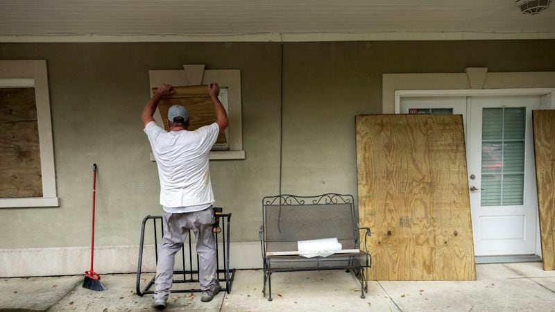 Tybee Island resident Bryan Moore helps his friend board up his house on Tybee Island, Tuesday, Aug., 29, 2023, ahead of Hurricane Idalia. Georgia Gov. Brian Kemp has declared a state of emergency. (Stephen B. Morton/AJC)