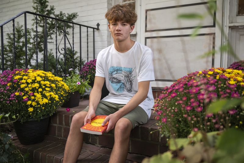 Chris Stanislawski, 14, poses for a portrait outside of his home in Garden City, N.Y., on Friday, Sept. 13, 2024. Chris didn't finish any books in his 8th grade English class, in part because their google classroom had detailed summaries of each chapter of every book. (AP Photo/Brittainy Newman)