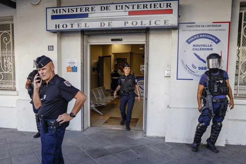 FILE - Police wait for the arrival of French President Emmanuel Macron at the central police station in Noumea, New Caledonia, Thursday, May 23, 2024. French authorities in New Caledonia regained full control of their Pacific territory's capital, the French interior and overseas minister said on Friday May 31, 2024 after two weeks of unrest that had left seven people dead and significant destruction in the archipelago with decades of tensions between those seeking independence and those loyal to France. (Ludovic Marin/Pool Photo via AP)