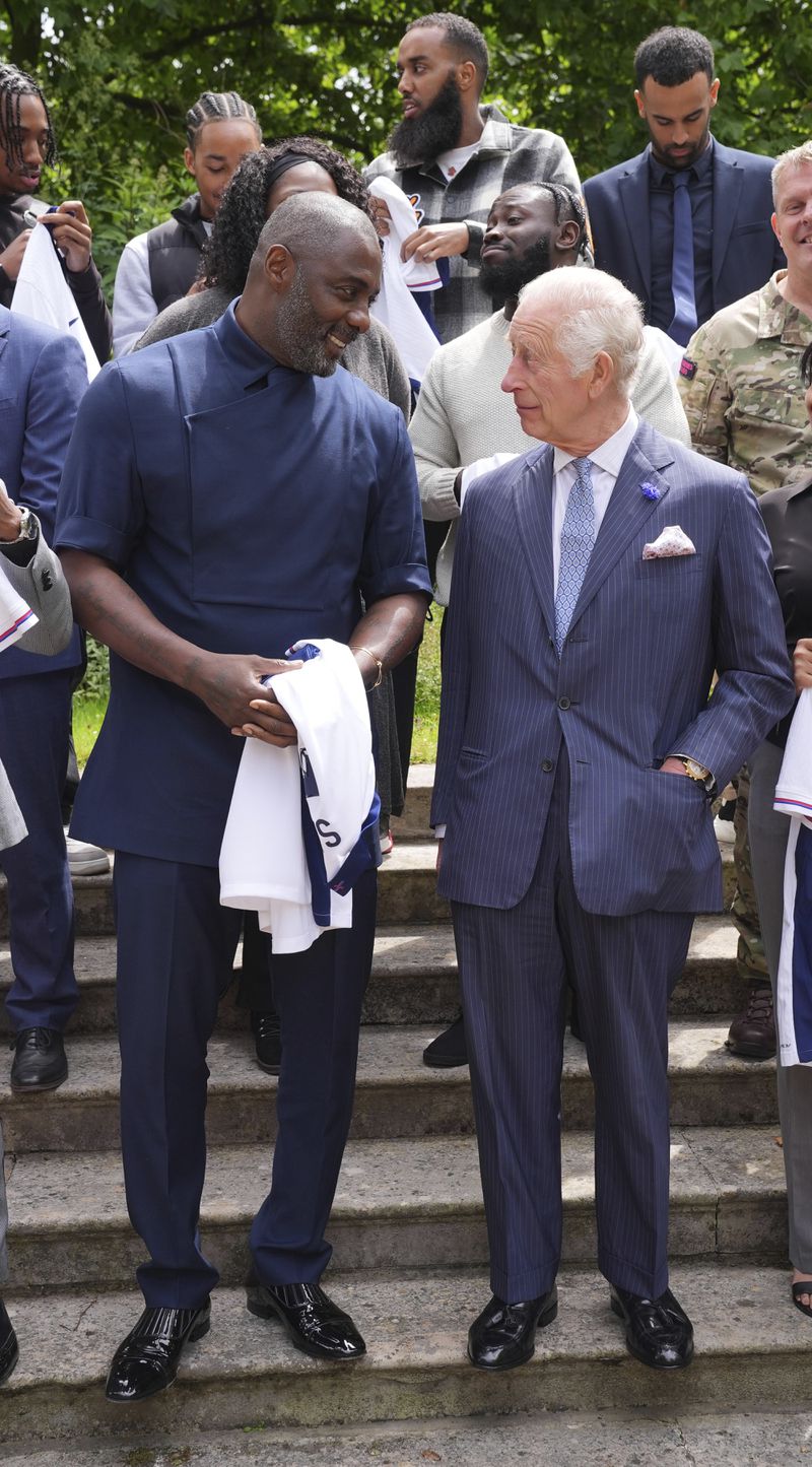 King Charles III with Idris Elba, left, and young people attend an event for The King's Trust to discuss youth opportunity, at St James's Palace in central London, Friday July 12, 2024. The King and Mr Elba, an alumnus of The King's Trust (formerly known as The Prince's Trust), are meeting about the charity's ongoing work to support young people, and creating positive opportunities and initiatives which might help address youth violence in the UK, as well as the collaboration in Sierra Leone between the Prince's Trust International and the Elba Hope Foundation. (Yui Mok/pool photo via AP)