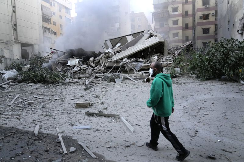 A man passes in front of a destroyed building that hit by an Israeli airstrike in Dahieh, Beirut, Lebanon, Wednesday, Oct. 2, 2024. (AP Photo/Hussein Malla)