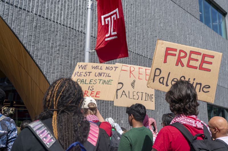 People hold up signs during a pro-Palestine rally and march on Temple University campus in Philadelphia, Aug. 29, 2024. (AP Photo/Chris Szagola)