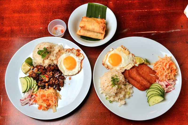 Silog is a traditional Filipino breakfast plate composed of sinangag (garlic fried rice), itlog (egg) and a protein. For his silog-themed pop-up, Adobo ATL owner Mike Pimentel offered silogs featuring crispy pork (left) and fried Spam (right). Filipino-style egg rolls known as lumpia (center), are a tasty treat any time of day. (CHRIS HUNT FOR THE ATLANTA JOURNAL-CONSTITUTION)