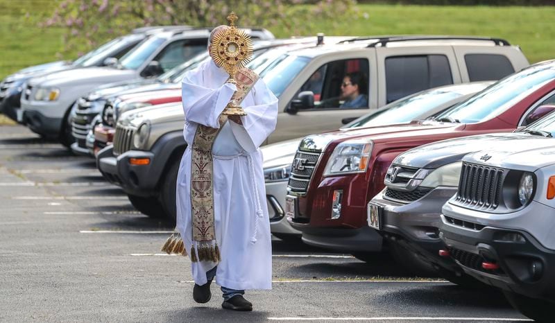 Deacon Fred Johns presided over "Drive-In" Adoration of the Most Blessed Sacrament Wednesday, March 25, 2020. Some 50-cars attended in the parking lot at St. Pius X Catholic Church in Conyers. Adoration is offered every weekday (weather permitting) from 9 a.m. to 10 a.m. Since the COVID-19 outbreak, Catholics in the Atlanta Archdiocese and around the world have been implementing creative ways to serve the faithful. JOHN SPINK/JSPINK@AJC.COM