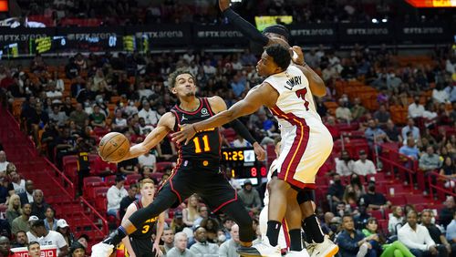 Atlanta Hawks guard Trae Young (11) passes the ball as Miami Heat guard Kyle Lowry (7) defends during the first half of an NBA basketball game Friday, April 8, 2022, in Miami. (AP Photo/Lynne Sladky)