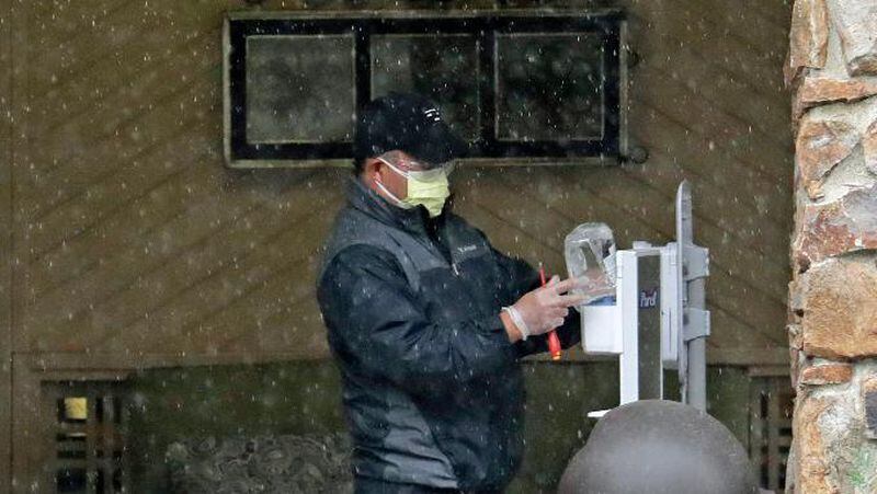 A worker adds hand sanitizer to a hygiene station at the Life Care Center in Kirkland, Washington, which has become the epicenter of the COVID-19 coronavirus outbreak in Washington state.