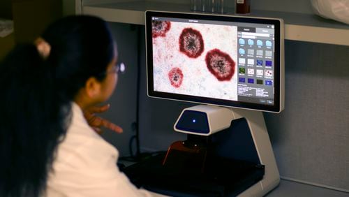 GeoVax scientist Pratima Kumari looks at an image of infected cells captured by a fluorescent microscope at the GeoVax laboratory in Smyrna,. GeoVax is working on developing a new COVID-19 vaccine, funded by a federal grant. (Jason Getz / AJC)