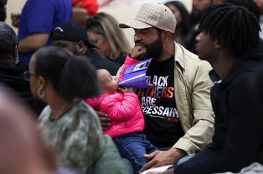 Milton Shabazz with his daughter, Zora. Shabazz is wearing a "Black Fathers are Necessary" shirt while attending a March 13 "Peace Not Guns" community Healing Town Hall meeting at Imhotep Institute Charter High School in Philadelphia. (Heather Khalifa/The Philadelphia Inquirer/TNS)