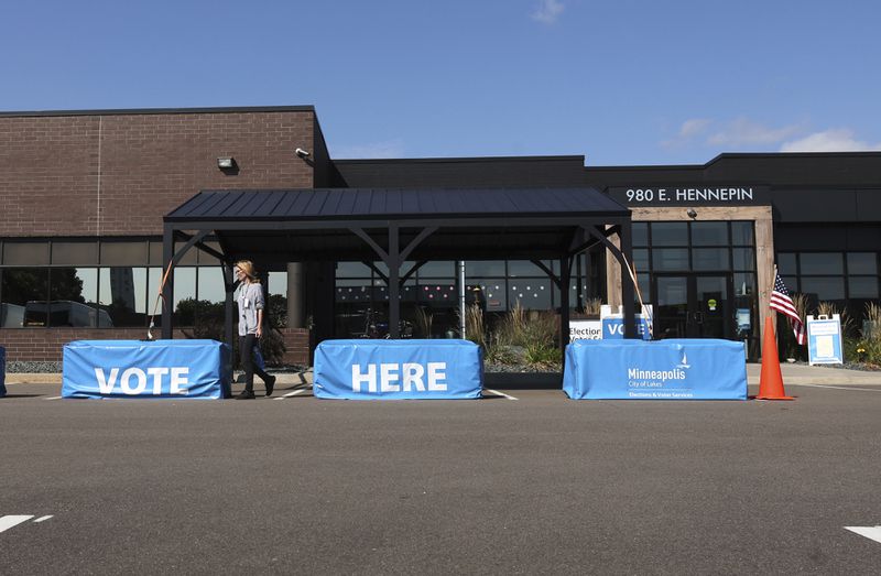 A member of the staff walks out of the City of Minneapolis early voting center, Thursday, Sept. 19, 2024, in St. Paul, Minn. In-person voting in the 2024 presidential contest begins Friday in three states, including Democratic vice presidential candidate Tim Walz's home state of Minnesota, with just over six weeks left before Election Day. (AP Photo/Adam Bettcher)