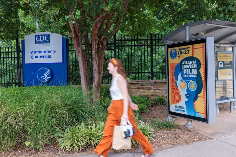 A person walks in front of the CDC entrance on Clifton Road, Which is near a MARTA stop, in Atlanta on Tuesday, August 2, 2022. (Arvin Temkar / arvin.temkar@ajc.com)