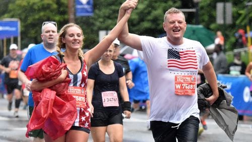 Runners react in different ways as they approach the finish line during the AJC Peachtree Road Race on Saturday, July 4, 2015. HYOSUB SHIN / HSHIN@AJC.COM