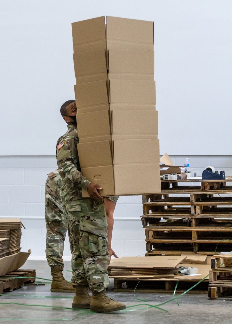 Members of the National Guard 1177th Transportation Company help to sort and pack boxes of supplies at the Atlanta Community Food Bank headquarters Friday, May 22, 2020. STEVE SCHAEFER FOR THE ATLANTA JOURNAL-CONSTITUTION