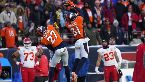 FILE - Denver Broncos safety Justin Simmons (31) intercepts a pass as teammate Damarri Mathis (27) watches during the second half of an NFL football game against the Kansas City Chiefs Sunday, Oct. 29, 2023, in Denver. Simmons was voted one of the top five safeties at the midpoint of the season by The Associated Press. (AP Photo/Jack Dempsey, File)