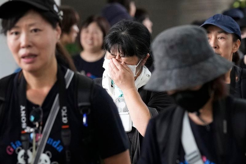 Visitors react after visiting the giant pandas Ri Ri and Shin Shin at Ueno Zoo, a day before their return to China, Saturday, Sept. 28, 2024, in Tokyo. (AP Photo/Eugene Hoshiko)