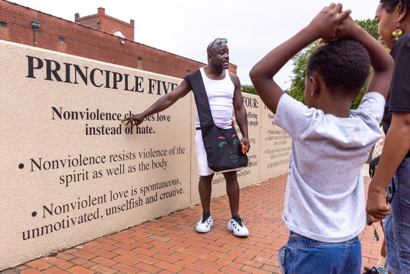 James Grimes teaches his grand-nephews about nonviolence at The King Center in Atlanta on Juneteenth, Monday, June 19, 2023. (Arvin Temkar / arvin.temkar@ajc.com)
