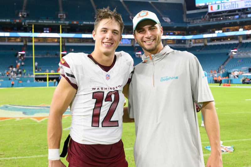 FILE - Washington Commanders wide receiver Luke McCaffrey, left, poses with his brother, Miami Dolphins offensive assistant Max McCaffrey on the field after an NFL pre-season football game, on Aug. 17, 2024, in Miami Gardens, Fla. Luke McCaffrey this weekend will become the latest member of his family to play in the NFL. (AP Photo/Doug Murray, File)