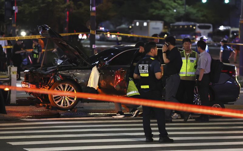 Police officers investigate a car accident scene near Seoul City Hall in downtown Seoul, South Korea, Monday, July 1, 2024. A car slammed into pedestrians in central Seoul on Monday night, killing nine people and injuring four others, officials said. (Seo Dae-yeon/Yonhap via AP)