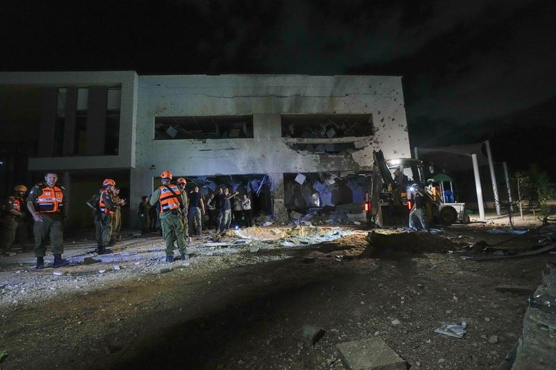 Israeli military and police work at a damaged school building that was hit by missiles fired from Iran in Gadera, Israel, Tuesday, Oct. 1, 2024. (AP Photo/Tsafrir Abayov)