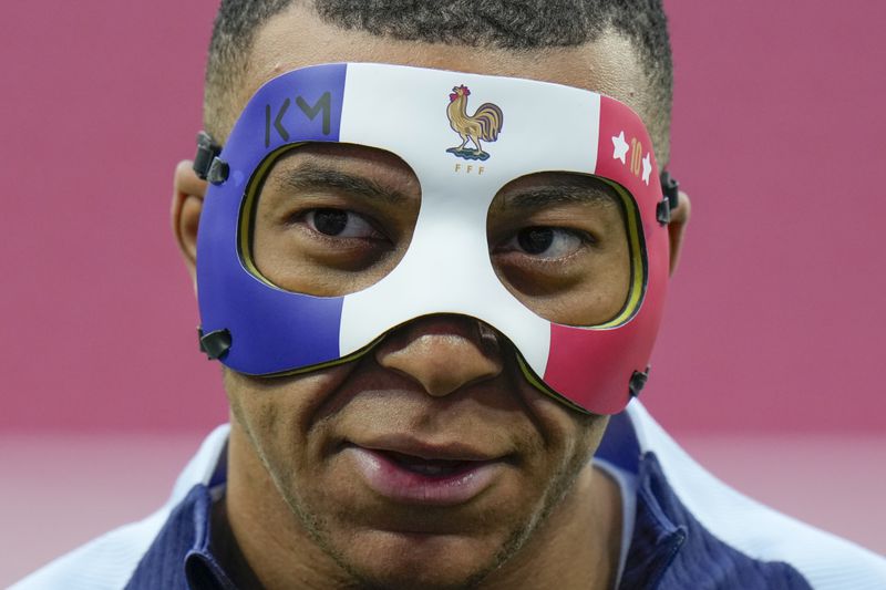 France's Kylian Mbappe wears a face mask as he runs during a training session in Leipzig, Germany, Thursday, June 20, 2024. France will play against Netherland during their Group D soccer match at the Euro 2024 soccer tournament on June 21. (AP Photo/Hassan Ammar)