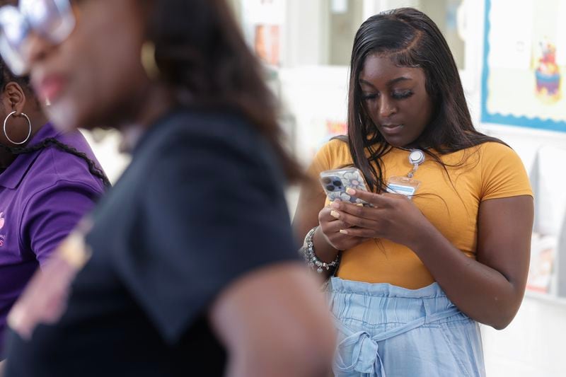 Shania Durham uses the Irth app to leave a review during a launch event at Sheltering Arms Educare Center in Atlanta on Thursday, June 15, 2023. The app is  “Yelp-like” review and rating platform for Black mothers to share birthing experiences to help make Black birth safer. (Natrice Miller/ Natrice.miller@ajc.com)