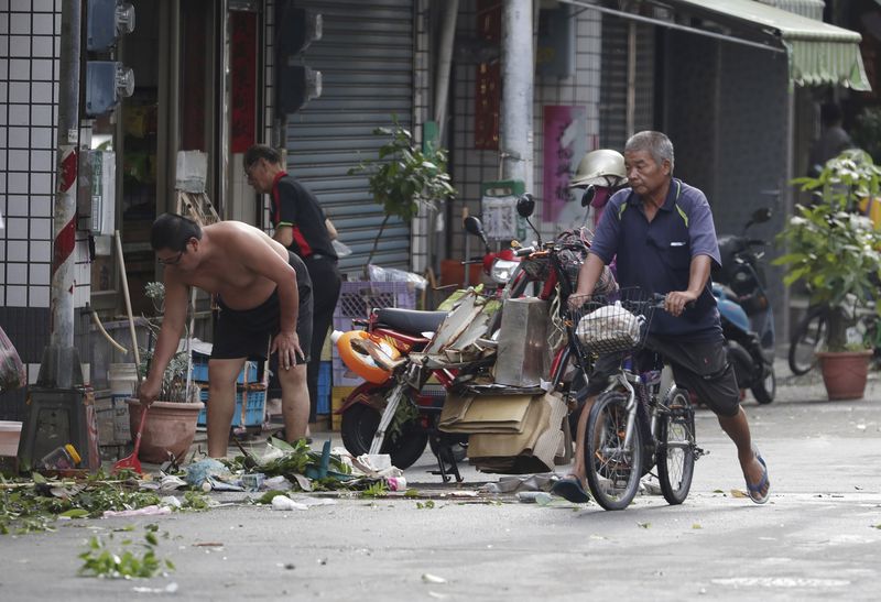 People clear debris in the aftermath of Typhoon Krathon in Kaohsiung, southern Taiwan, Friday, Oct. 4, 2024. (AP Photo/Chiang Ying-ying)