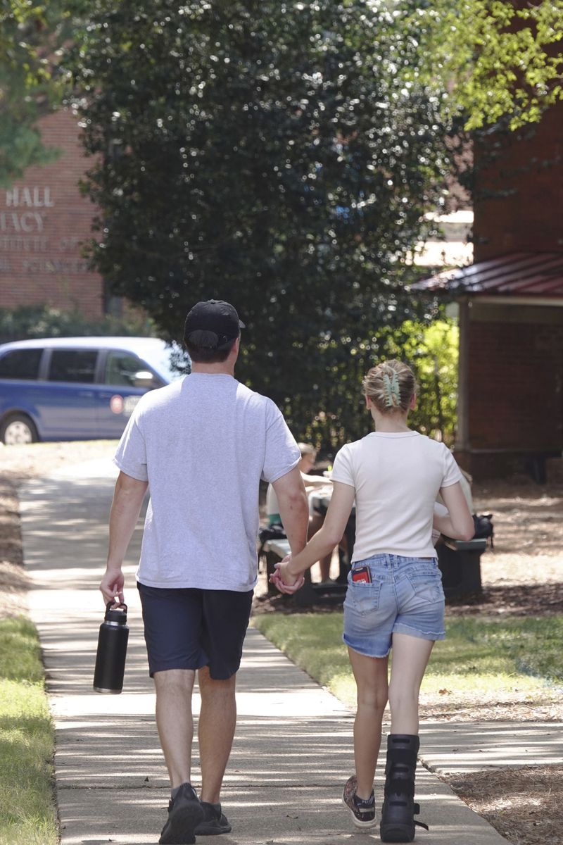 A couple holds hands at the University of Mississippi campus in Oxford, Miss., Wednesday, Aug. 28, 2024. (AP Photo/Karen Pulfer Focht)