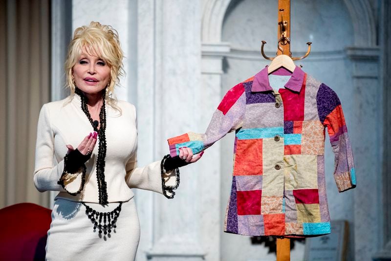 Singer-songwriter Dolly Parton speaks at an event where her organization, Imagination Library, donates the 100 millionth book, Dolly Parton's "Coat of Many Colors," to the Library of Congress collection, Tuesday, Feb. 27, 2018 in Washington. The Library of Congress and Imagination Library also announce a story time for children on the last Friday of each month in the Great Hall of the Thomas Jefferson Building from March through August. (AP Photo/Andrew Harnik)
