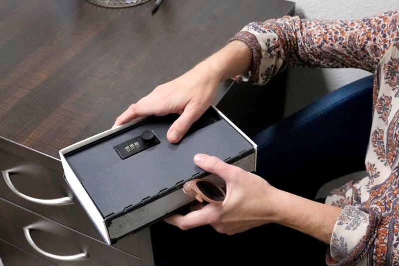 Methadone patient Irene Garnett, 44, of Phoenix, holds her medication lock box at a clinic in Scottsdale, Ariz., on Monday, Aug. 26, 2024. (AP Photo/Ross D. Franklin)