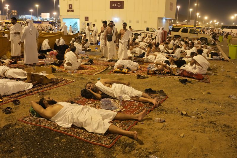Muslim pilgrims rest in Muzdalifah, on the second day of the annual hajj pilgrimage, near the holy city of Mecca, Saudi Arabia, Saturday, June 15, 2024. (AP Photo/Rafiq Maqbool)