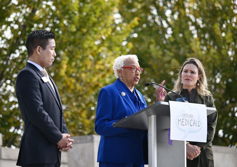 Senator Gloria Butler speaks as Representative Sam Park (left) and Senator Elena Parent stand next her during a press conference calling for full Medicaid expansion, after Gov. Brian Kemp's strict new Medicaid program "Pathways to Coverage" announced at Liberty Plaza, Wednesday, October 25, 2023, in Atlanta. (Hyosub Shin / Hyosub.Shin@ajc.com)