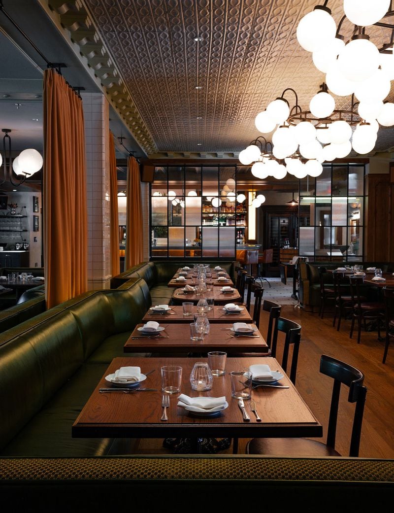 Bulbous chandeliers cast a glow over the rich wood and dark leather of Little Sparrow's well-appointed dining room. Courtesy of Little Sparrow