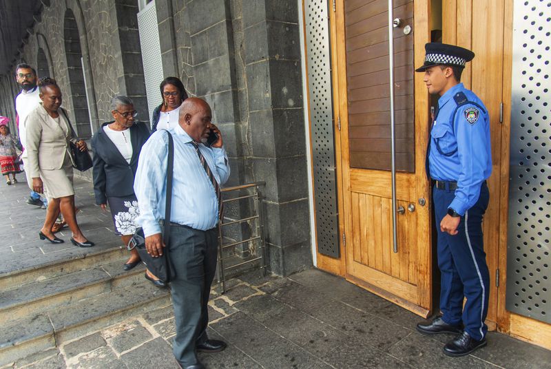 Chagossians, led by Olivier Bancoult, on phone at center, outside the Mauritian Prime Minister's office in Port Louis, Mauritius, Thursday, Oct. 3, 2024, after the news that the U.K. had agreed to hand sovereignty of the long-contested Chagos Islands to Mauritius. (Sokrah Kiranchand/l'Express Mauritius via AP)