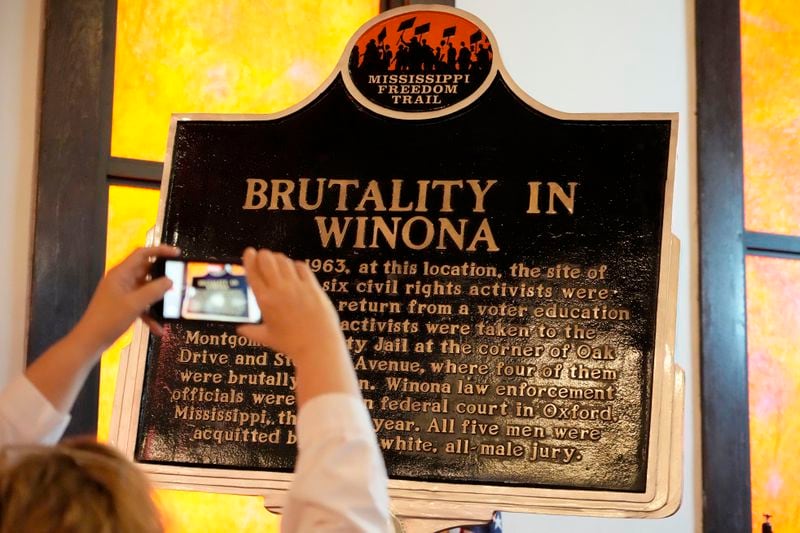 An attendee takes a cell phone photo, June 8, 2024, following the unveiling in Winona, Miss., of a Mississippi Freedom Trail marker commemorating the brutality faced by Fannie Lou Hamer and other civil rights activists who were arrested in June 1963, at a bus station in Winona as they returned from an out-of-state citizenship training session. (AP Photo/Rogelio V. Solis)