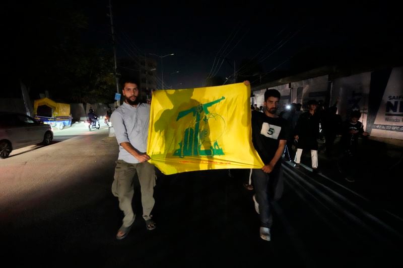 Kashmiri Shiite Muslims holds flag of Hezbollah during a protest against the killing of Hezbollah leader Hassan Nasrallah, in Srinagar, Indian controlled Kashmir, Saturday, Sept. 28, 2024. (AP Photo/Mukhtar Khan)