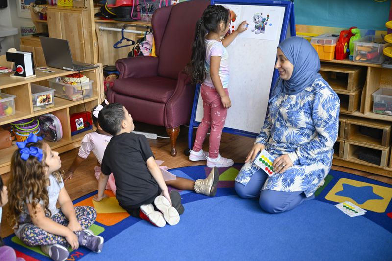 Preschool teacher Tinhinane Meziane, right, watches her students vote the most popular character of the TV show PAW Patrol at the ACCA Child Development Center, Thursday, Sept. 19, 2024, in Annandale, Va. The students are getting foundational lessons on how to live in a democracy by allowing them to regularly vote on different things through out the day. (AP Photo/John McDonnell)