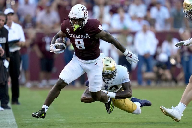 Texas A&M running back Le'Veon Moss (8) is tackled after a first down run by Notre Dame linebacker Jaylen Sneed (3) during the first half of an NCAA college football game Saturday, Aug. 31, 2024, in College Station, Texas. (AP Photo/Sam Craft)