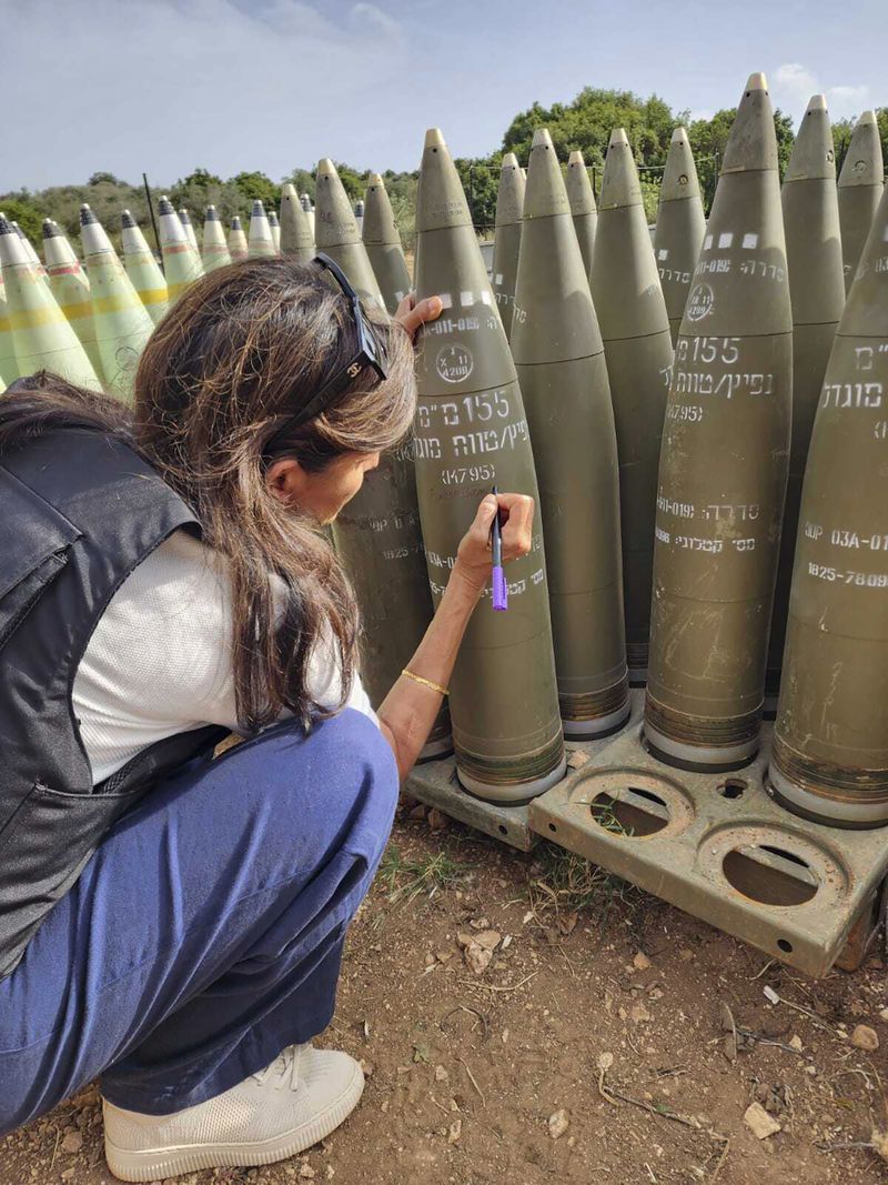 This photo provided by the Office of Israeli lawmaker Danny Danon, shows former U.S Ambassador to the United Nations, Nikki Haley signing an Israeli artillery shell while touring Israel’s northern border with Lebanon on Tuesday, May 28, 2024. Haley's visit comes as Israel faces heightened criticism for not doing enough to protect civilians in Gaza amid its war against Hamas, and days after Israeli airstrikes triggered a fire in a camp for displaced Palestinians that appeared to be one of the war’s deadliest attacks. (Office of Israeli lawmaker Danny Danon via AP)