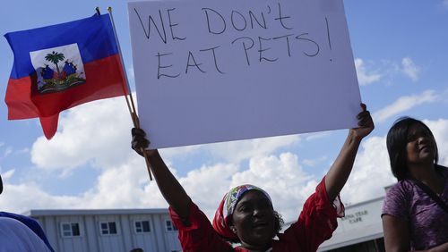 Wilda Brooks of West Palm Beach, Fla., holds up a sign reading "We don't eat pets," during a rally by members of South Florida's Haitian-American community to condemn hate speech and misinformation about Haitian immigrants, Sunday, Sept. 22, 2024, in North Miami, Fla. (AP Photo/Rebecca Blackwell)